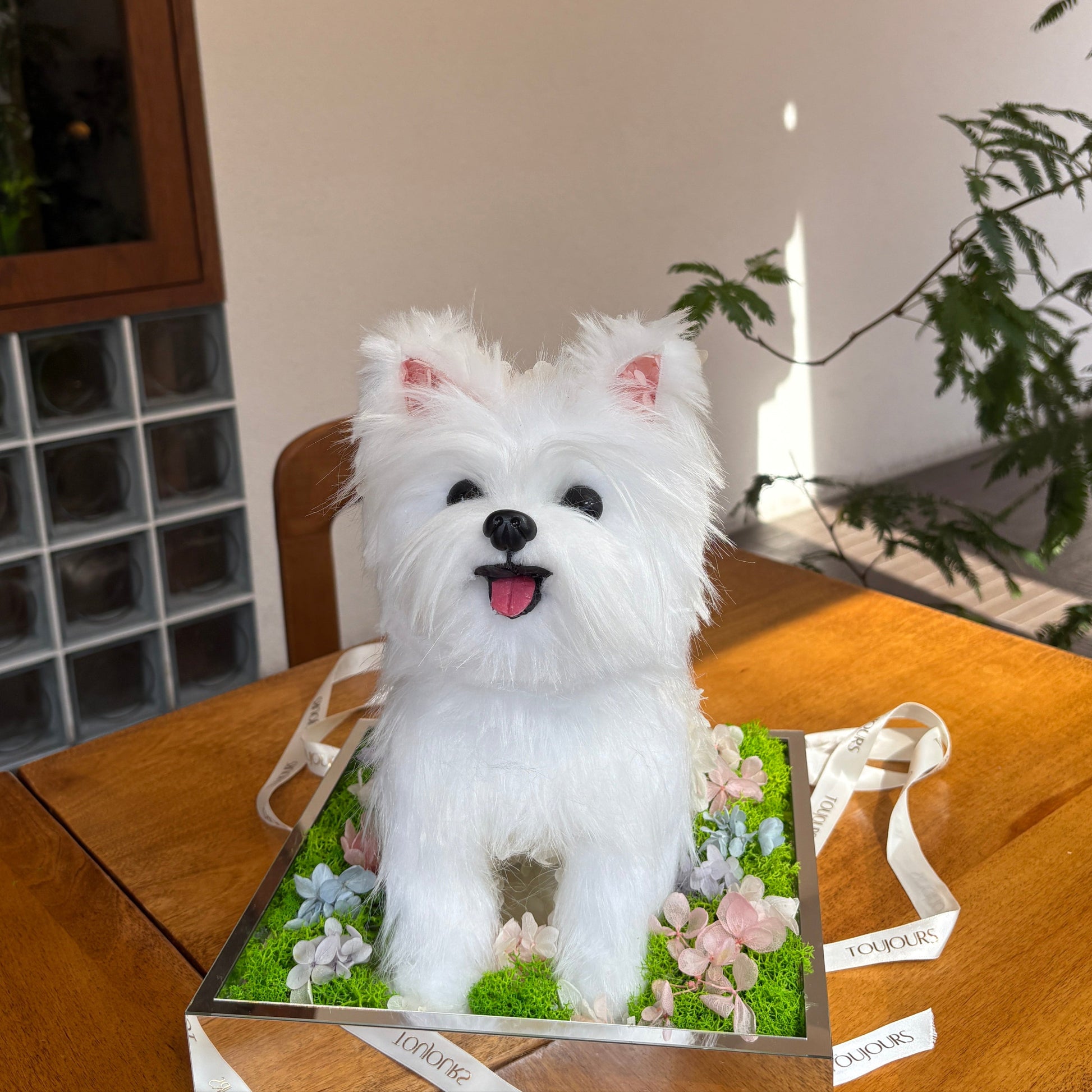 White dog toy on a box with floral design on a wooden surface