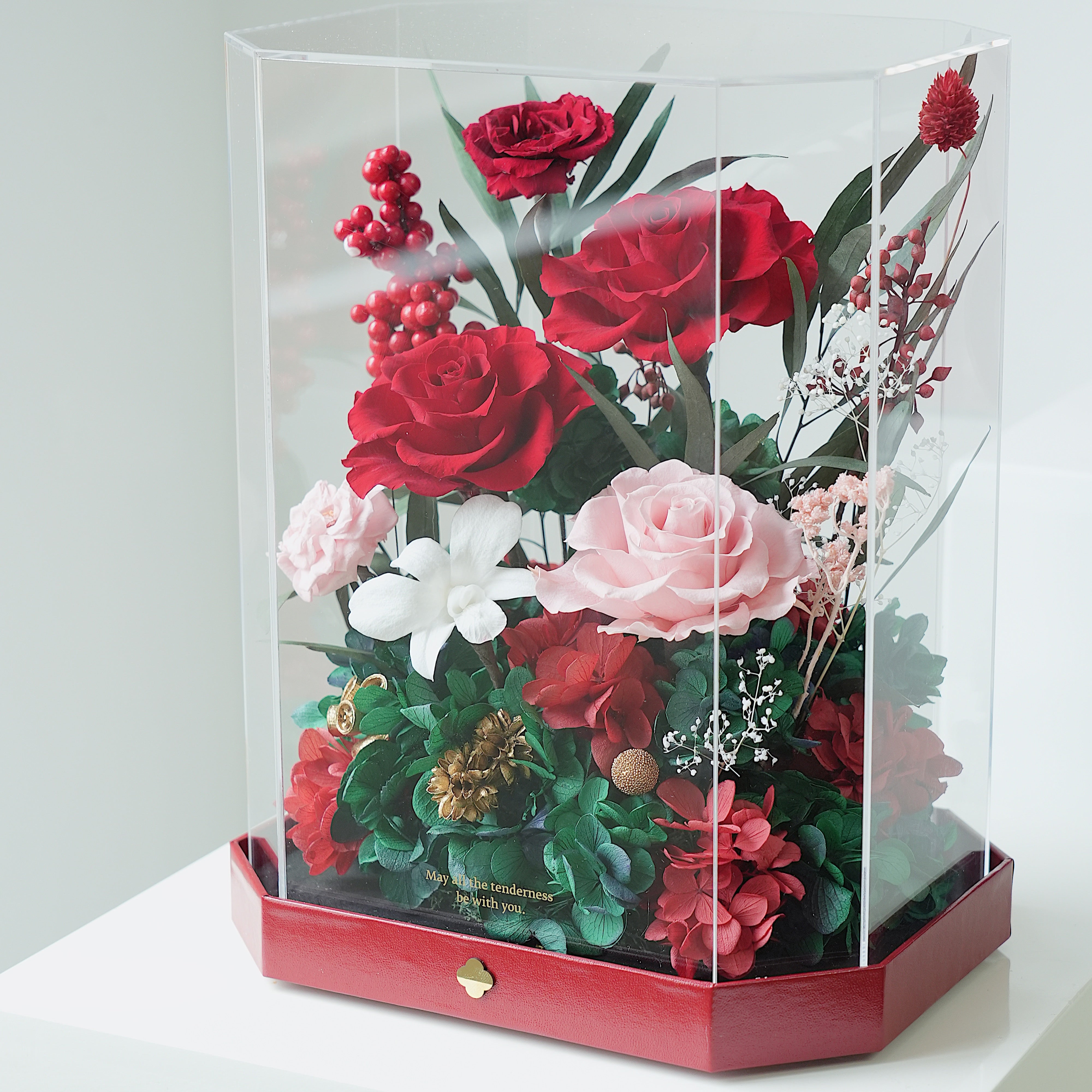 Hexagonal clear box with red and pink flowers on a white background