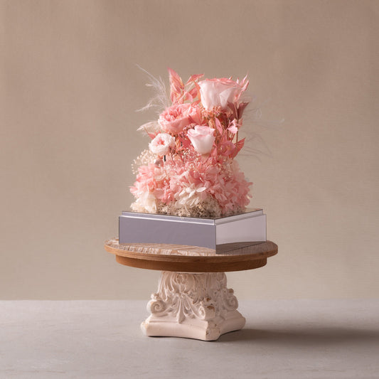Decorative floral arrangement on a small stand with a beige background