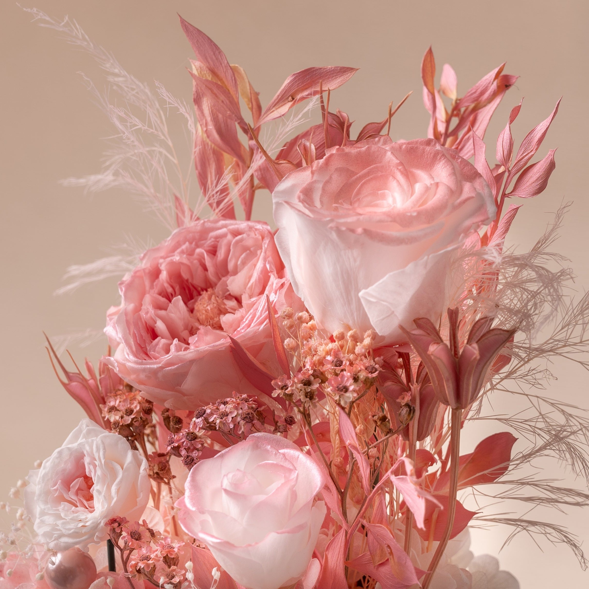 Bouquet of pink and white flowers with dried elements on a beige background