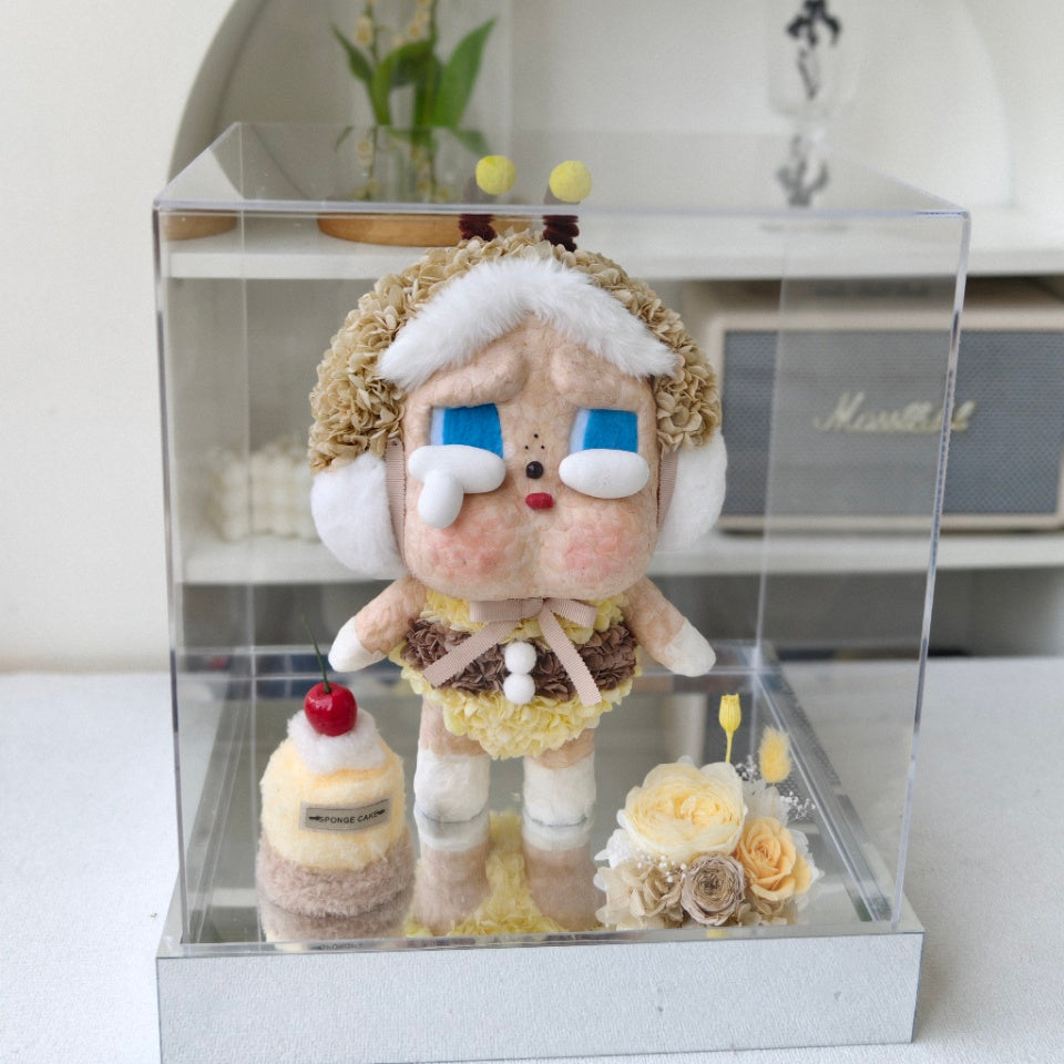 Flower Crybaby-I'll bring you a flower with a cake and flowers in a clear display case on a white surface.