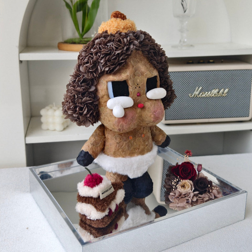 Flower Crybaby-baby brown with a cake and flowers on a reflective surface