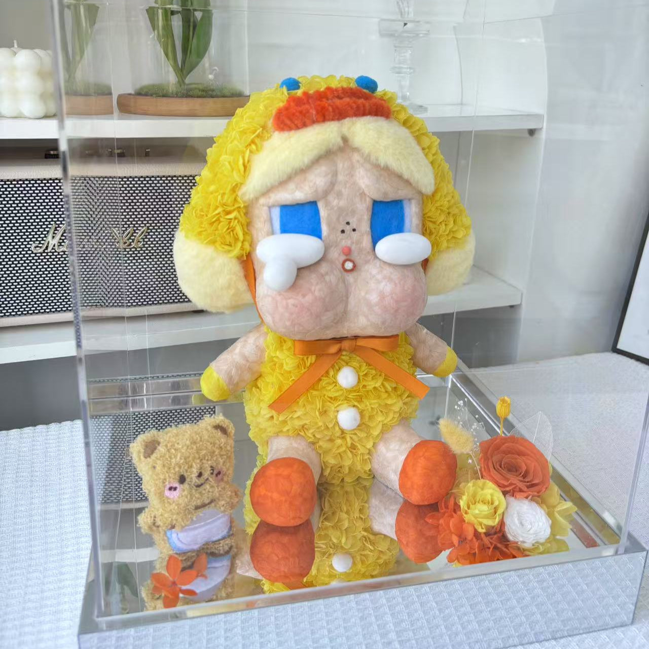Flower Crybaby-duck you with yellow hair and blue eyes in a clear display case.