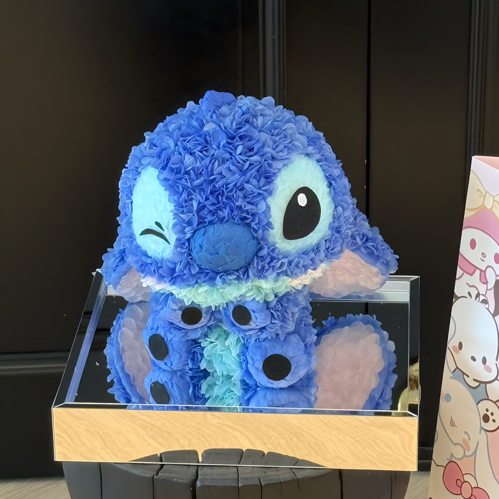 Blue plush toy resembling Stitch on a black surface with a blurred background