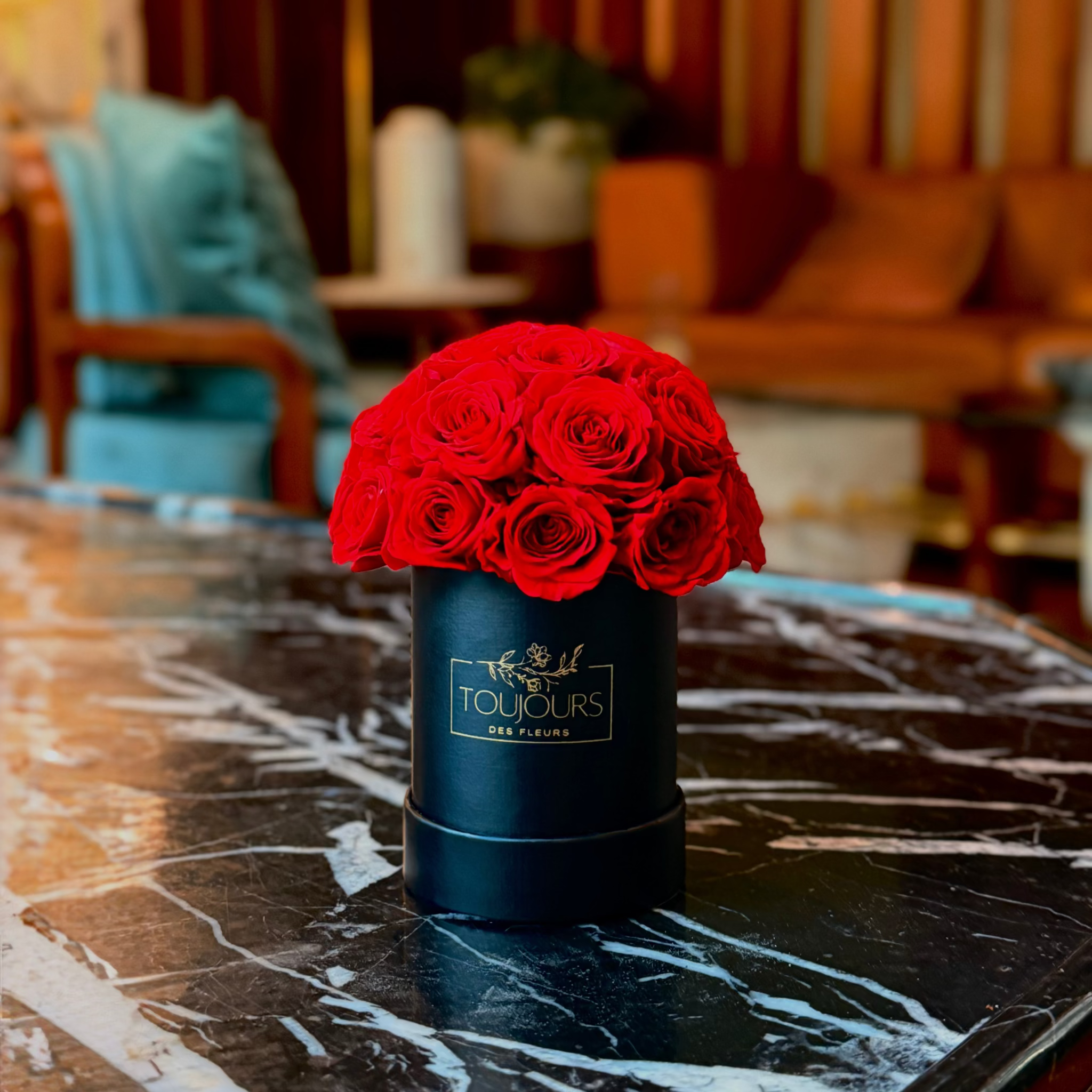 Black box with red roses on a marble table in an elegant room.