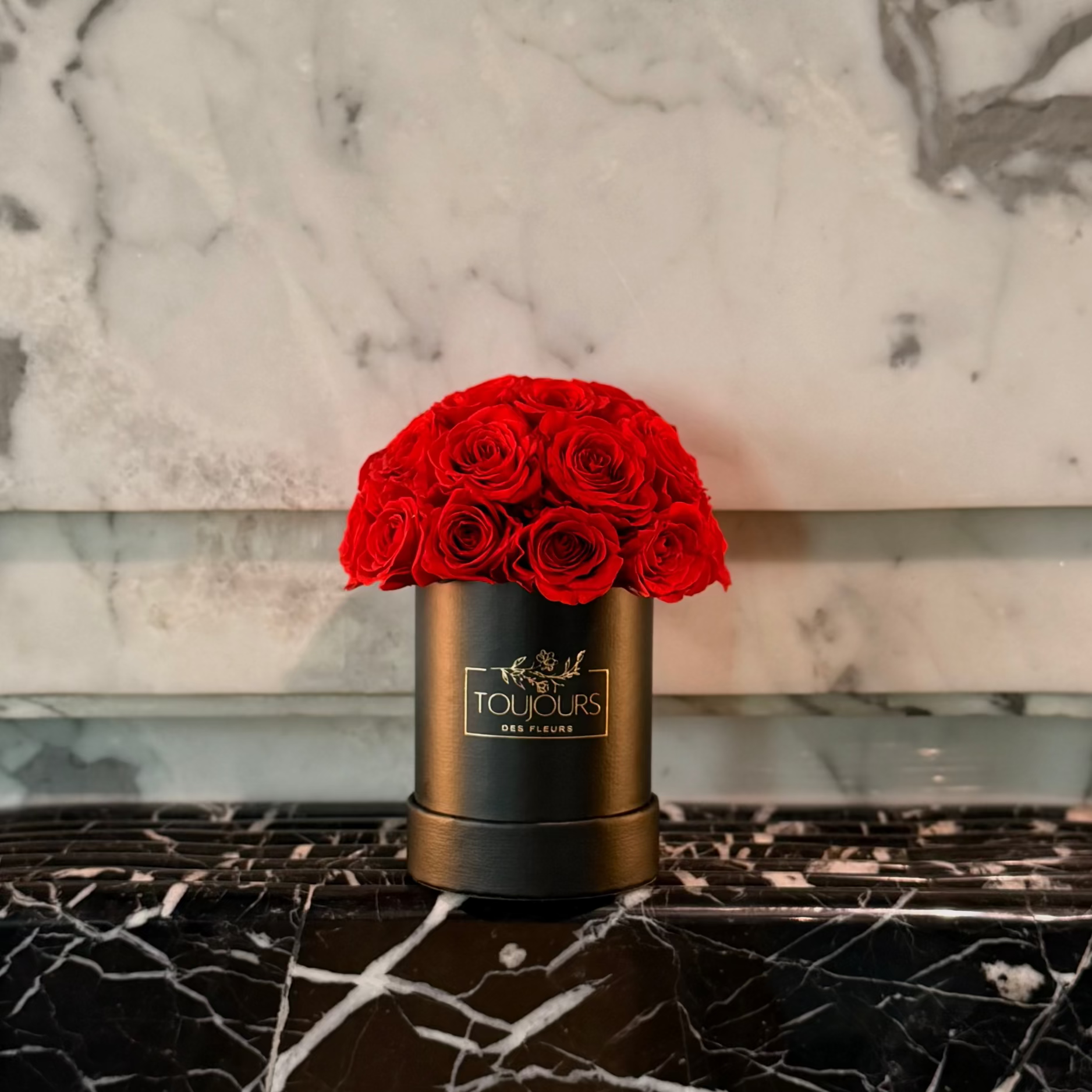 Black box with red roses on a marble surface