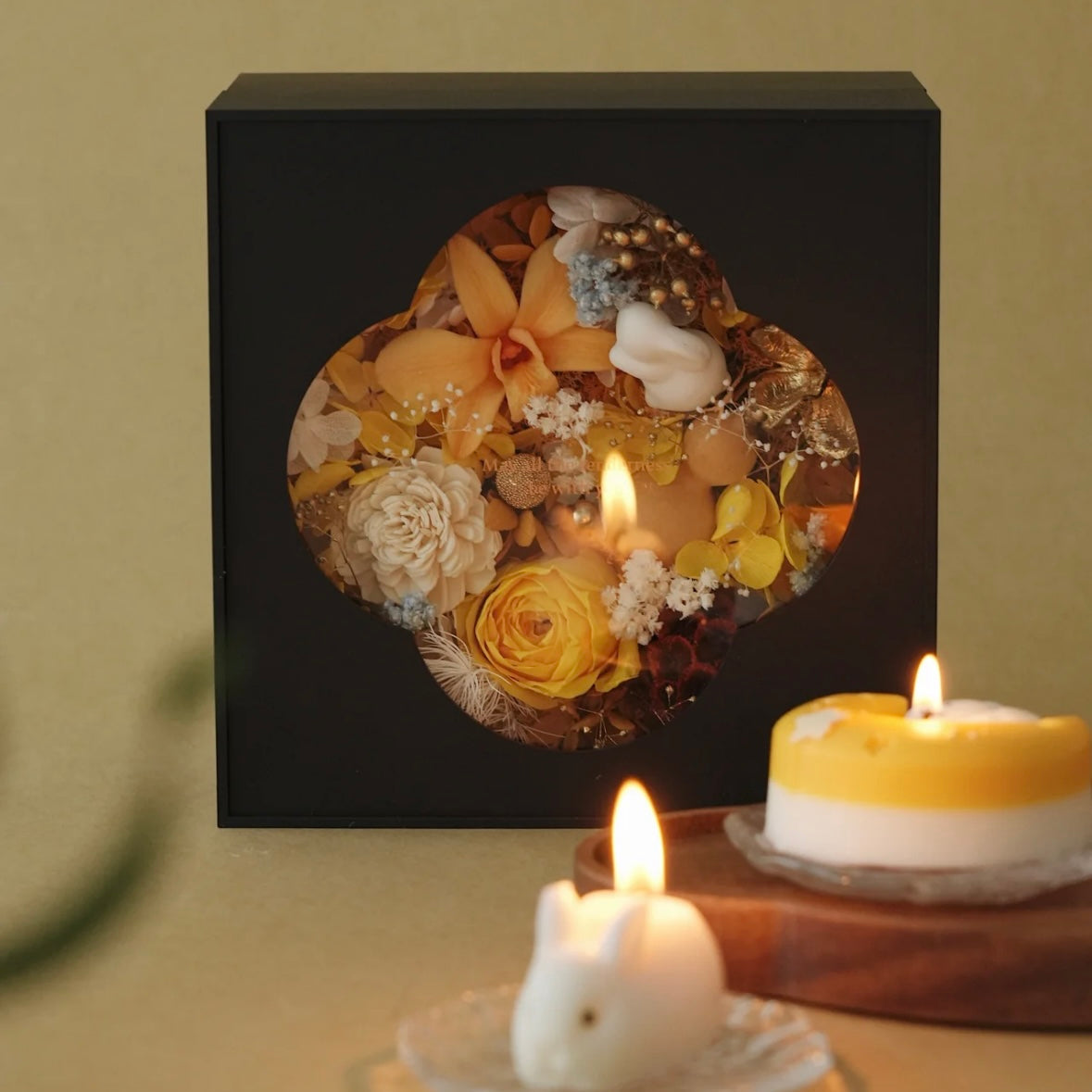 Decorative box with pressed flowers on a table with lit candles