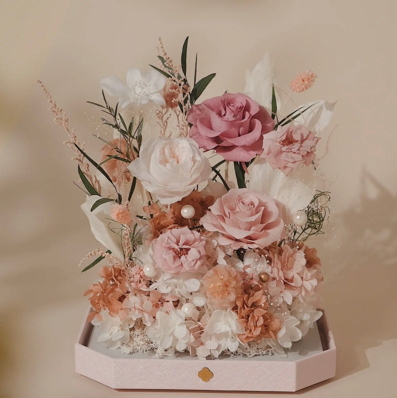 Bouquet of pink and white flowers in a hexagonal box on a blurred background