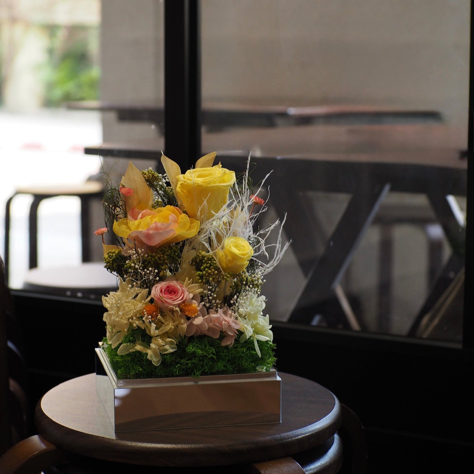 Floral arrangement on a small round table with a blurred background