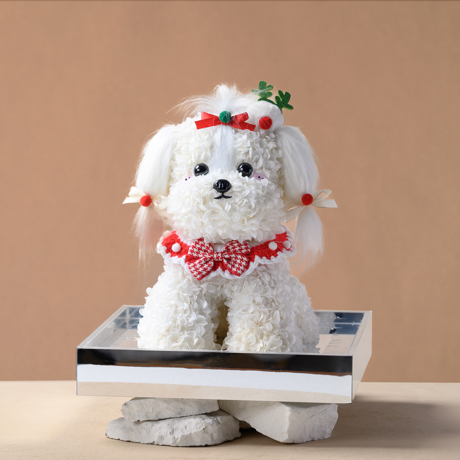 White dog-shaped flower with red bow and decorations on a beige background