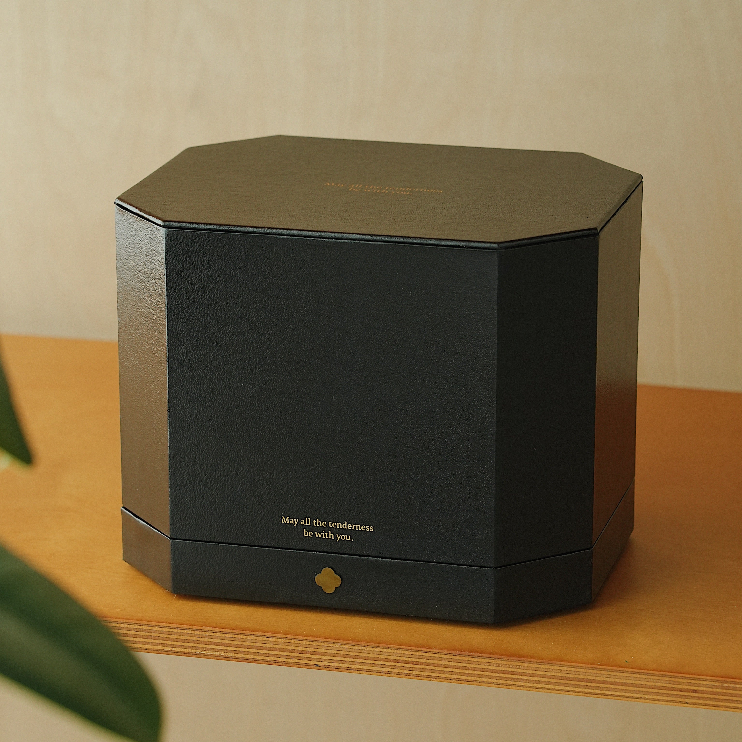 Black hexagonal box with text on a wooden surface